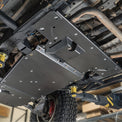 Detail of the DRT flat belly skid plate at the transfer case area showing the 4-inch clearance gain