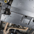Installed view of the DRT flat belly skid plate from the rear of the Tacoma with off-road tires visible