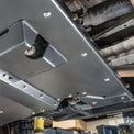Close-up of the DRT high-clearance transmission crossmember bolted into the Tacoma frame