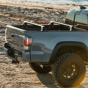 DRT Lo-Pro bed bars installed in the bed of a Toyota Tacoma 3rd Gen with a roof top tent mounted
